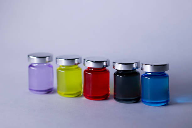 istock Little bottles with multicoloured liquid on white-gray background. Isolated. Board games. Cure - medicine, vaccine. Coronavirus or covid-19 - pandemic 1243320895