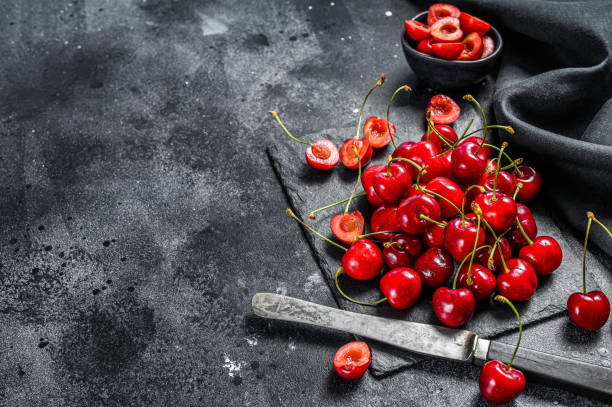 istock Cherries on black cutting board. fresh ripe cherries. Black background. Top view. Copy space 1243322021