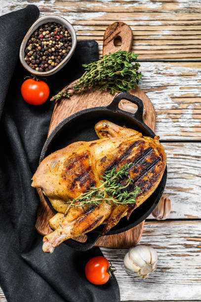 istock Baked whole farm chicken with thyme. White background. Top view 1243332808