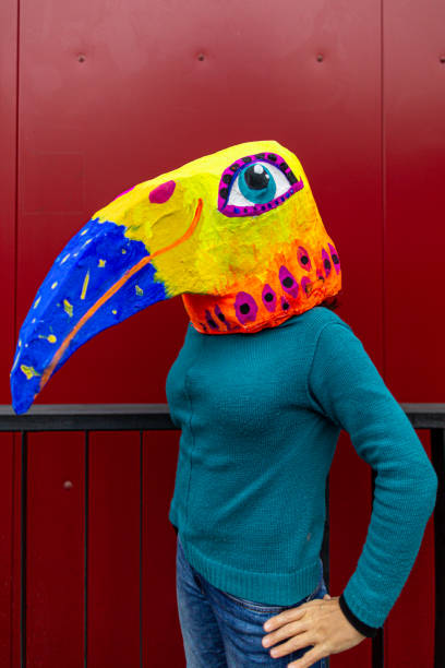 istock Woman wearing hand made bird's head mask 1243333978