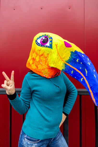 istock Woman wearing hand made bird's head mask 1243334572