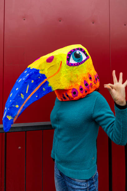 istock Woman wearing hand made bird's head mask 1243335160