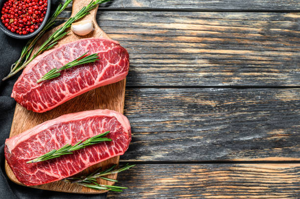 istock Raw marbled beef steak, top blade meat steak. Black background. Top view. Copy space. 1243338052