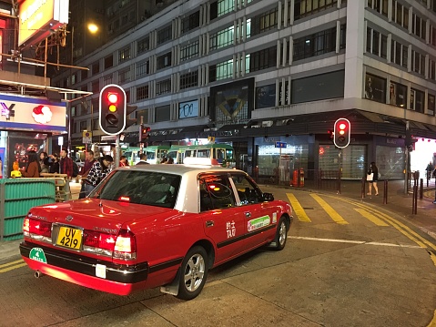 Hong Kong, Hong Kong - 12 04 2017: Hong Kong red taxi cab in business financial district downtown.