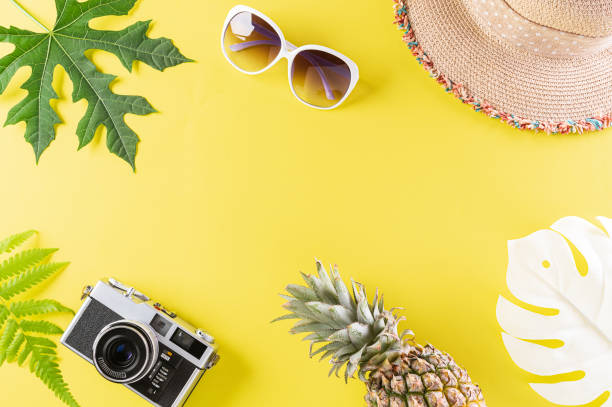 istock Colorful summer and holiday concept, Straw hat, sunglasses, palm branches, pineapple, star fish  and retro camera on yellow background. 1243369646