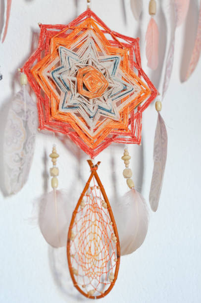 istock Closeup dreamcatcher with two God's eye mandalas and feathers on wall background 1243370265
