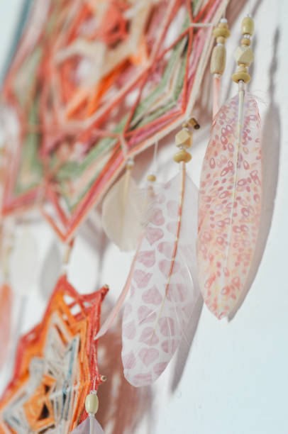 istock Closeup dreamcatcher with two God's eye mandalas and feathers on wall background 1243370816