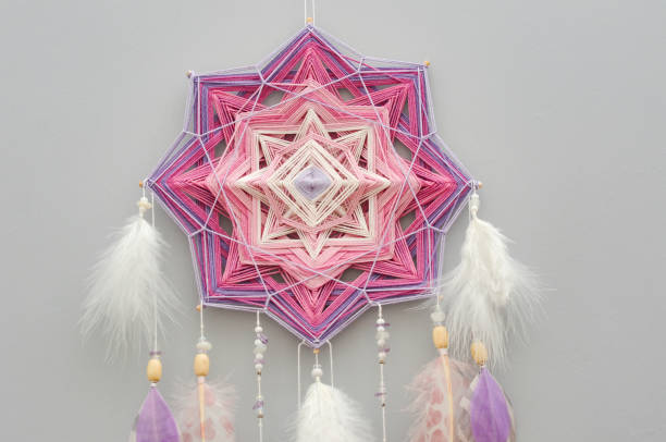 istock Mandala dream catcher with feathers and amethyst beads on grey background 1243375187