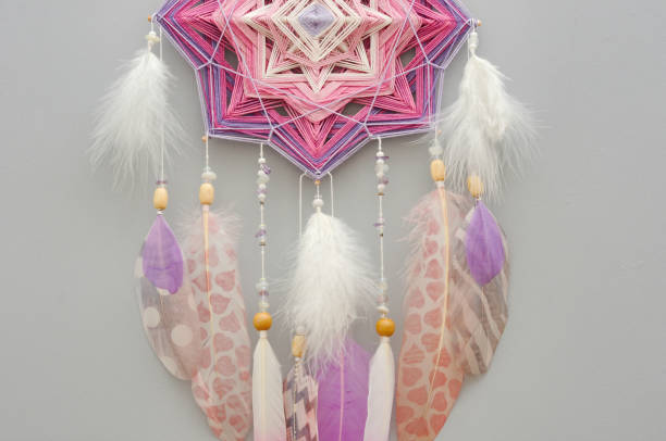 istock Mandala dream catcher with feathers and amethyst beads on grey background 1243375656