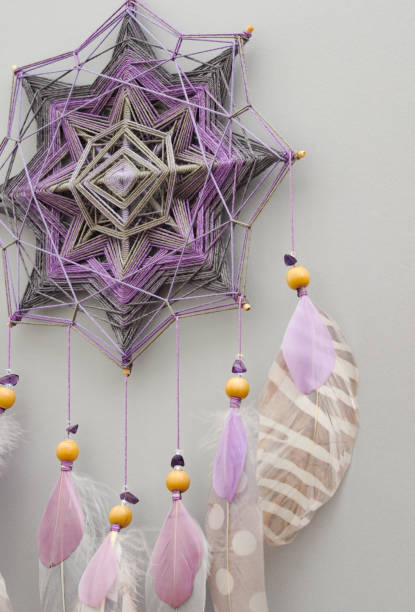 istock Mandala dream catcher with feathers and amethyst beads on grey background 1243376174