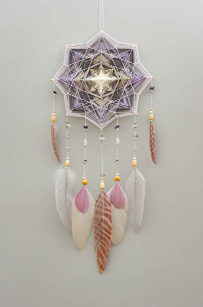 istock Mandala dream catcher with feathers and amethyst beads on grey background 1243376712
