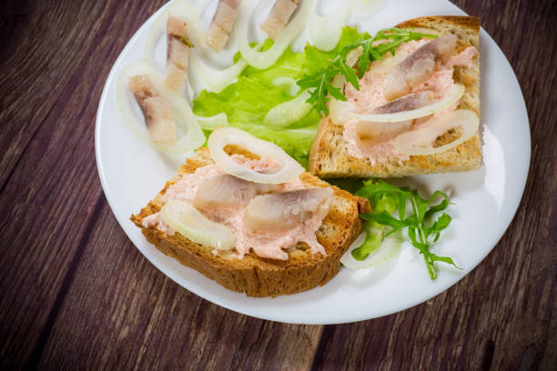 istock sandwich with salad, herring and herbs with onions in a plate 1243383201