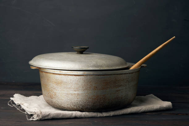 aluminum old cauldron on a wooden table, kitchen utensils, close up