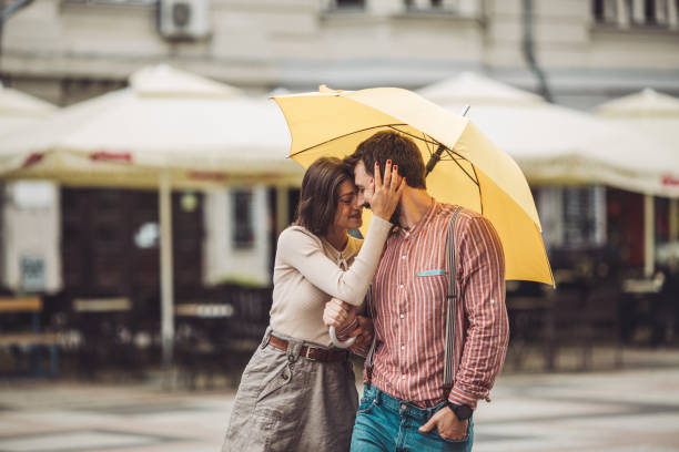 istock Young couple in love embracing under umbrella. 1243407052