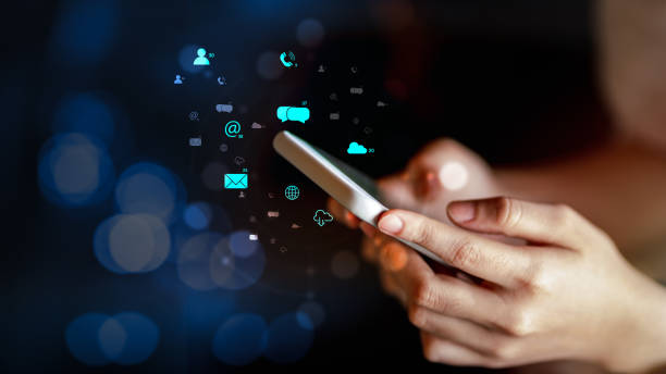 istock Woman using smartphone with multimedia digital icons 1243420217