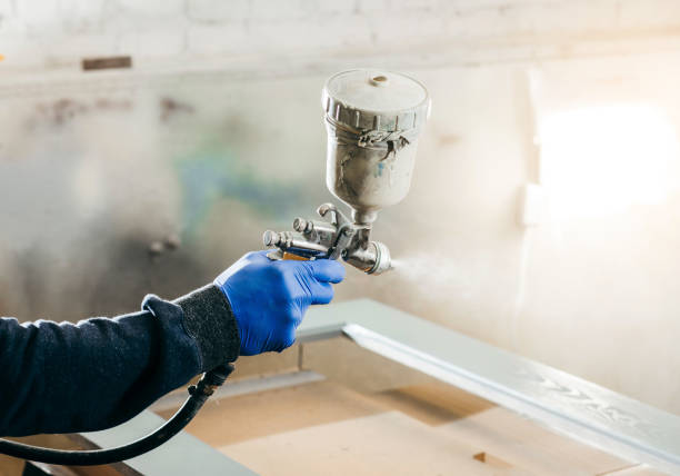 main de maître peintre dans une usine, bois industriel de peinture avec le pistolet de pulvérisation près vers le haut. - gas fitter photos photos et images de collection