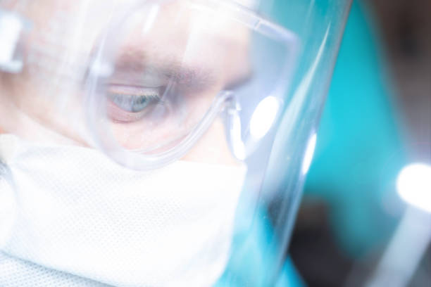 istock surgeon with glasses and a protective shield and mask. Young specialist works in the operating room 1243428464