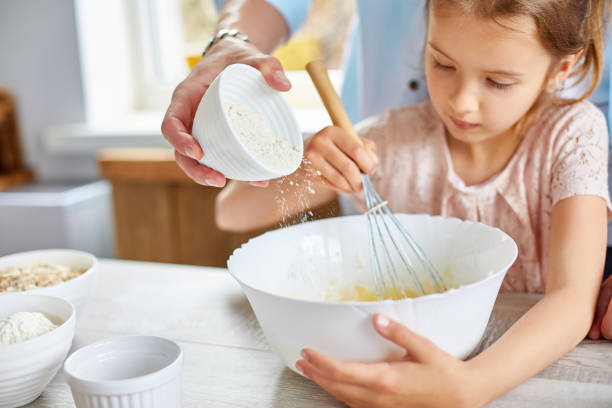 istock Father and daughter preparing dough together in kitchen 1243430580