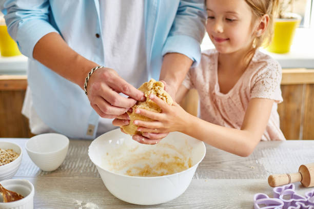 istock Father and daughter preparing dough together in kitchen 1243430593