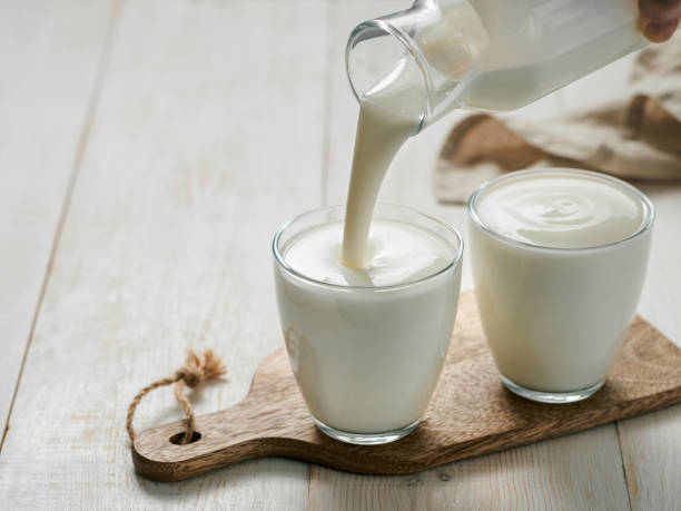 pouring kéfir casero, suero de leche o yogur - leche fotos fotografías e imágenes de stock