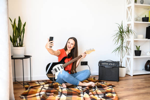 Woman makes selfie with an electric guitar