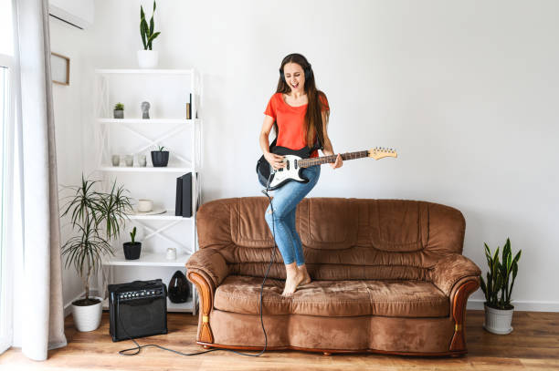 istock woman with an electric guitar dances on a sofa 1243443121
