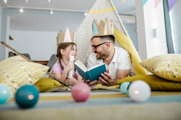 vater liest der tochter ein buch vor - grandparent family reading inside of stock-fotos und bilder