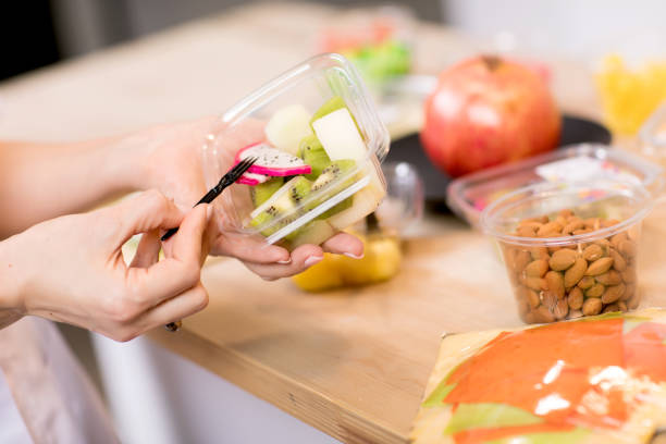 istock Hands holding Fresh fruits salad in box 1243460483