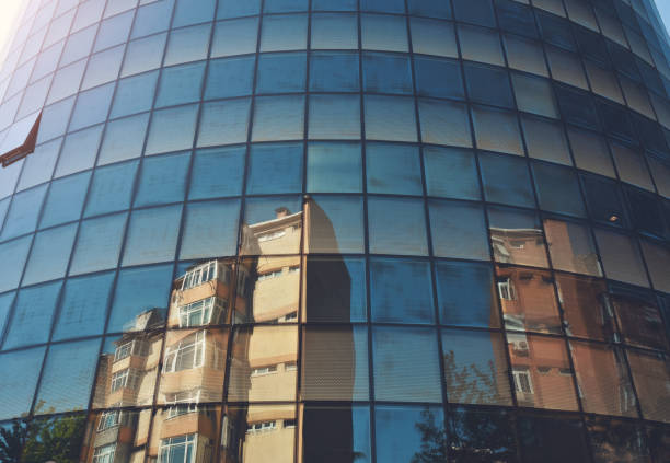 Facade of circle shape business center with reflection old apartments