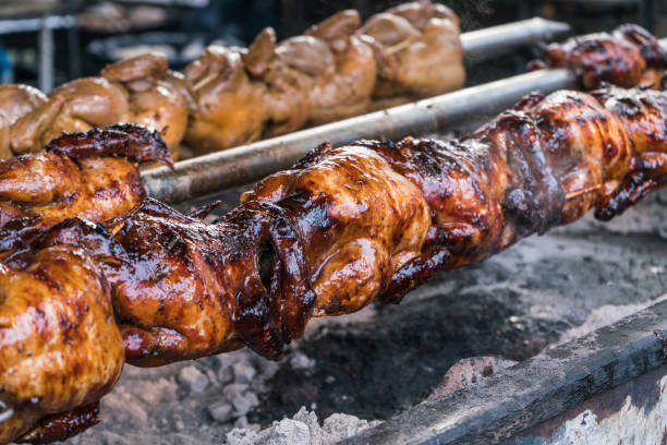 Thai food Grilled chickens in spinning rolls smoking meat rotisserie barbecue grill stock pictures, royalty-free photos & images