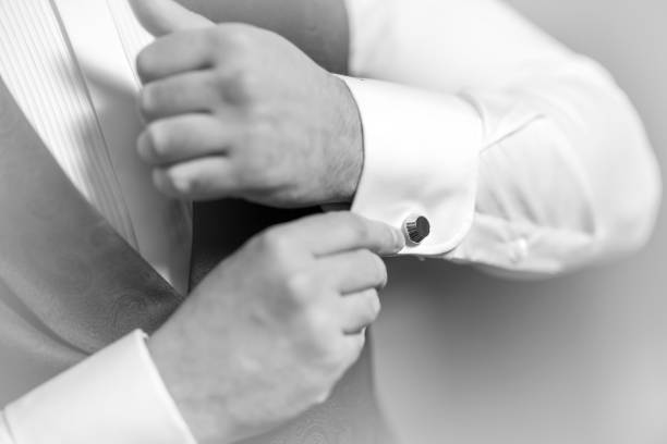 istock Hand's groom wears a metallic silver cufflinks stud. stylish wedding accessories. 1243479523