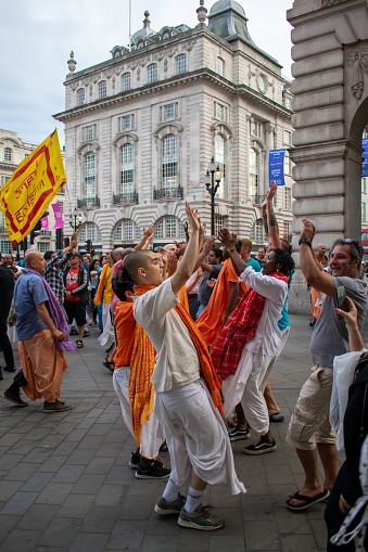 London, UK - 23 June, 2018: Hare Krishna's dancing in Piccadilly Circus, London, United Kingdom. London is the capital city of England in the United Kingdom and plays host to an average of over 18 million tourists per year.