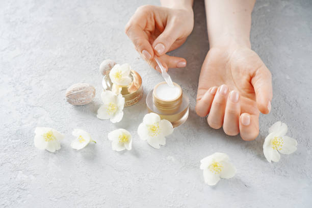 istock Female hands putting  face cream on a cosmetic spoon 1243543830