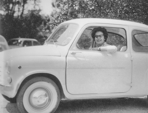 Young woman driving  car in 1960.