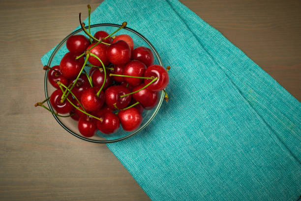 Green spring red cherries on wooden background cherry