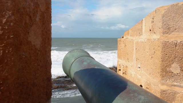 POV flying over cannon in old fortress to a view of the Atlantic ocean