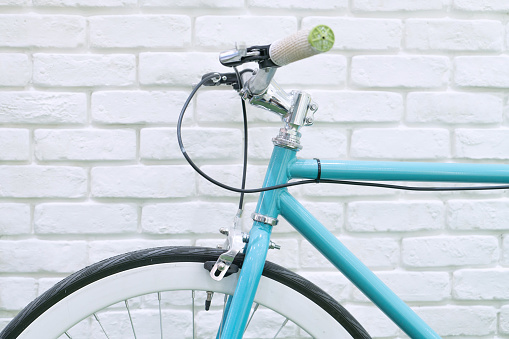 Close up photography of pastel toned bicycle  parking with white brick background