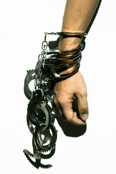 Harsh light image of hand with many handcuffs stock photo