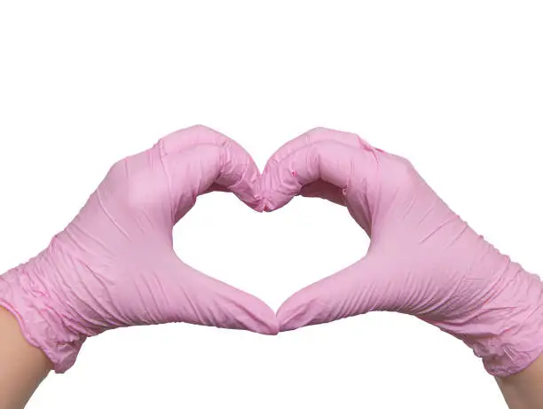 Photo of Hands in pink heart-shaped medical gloves, with love to the doctors of the world, isolated on white, copy space