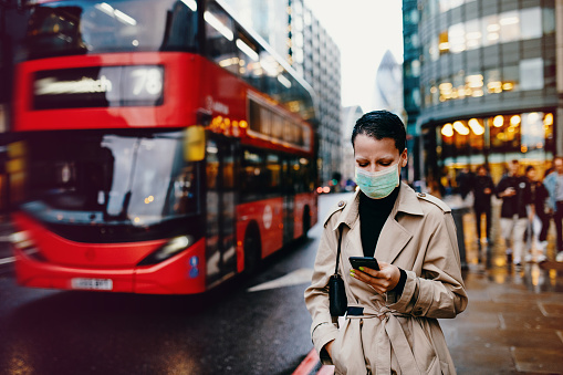 Trabajador esencial en Londres con máscara facial volver a casa después del trabajo con máscara facial en photo