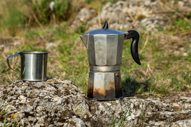 istock Metal cup and coffee maker in nature. Making coffee. Camping in summer. 1243592831