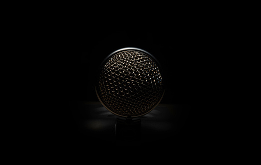 Close up of a microphone on black background