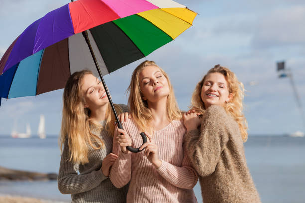istock Three women under colorful umbrella 1243614844