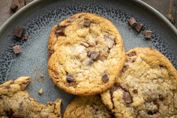istock Four freshly baked chocolate chip cookies on ceramic plate 1243631859