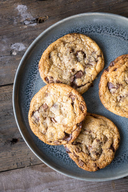 istock Four freshly baked chocolate chip cookies on ceramic plate 1243632029