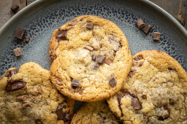 istock Four freshly baked chocolate chip cookies on ceramic plate 1243632408