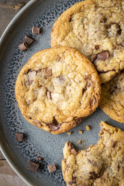 istock Four freshly baked chocolate chip cookies on ceramic plate 1243632923