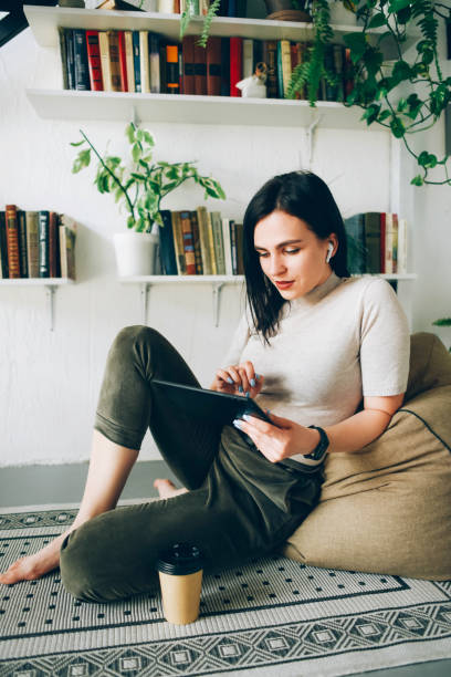 istock A girl sits on the floor at home and communicates via a webcam. 1243637855