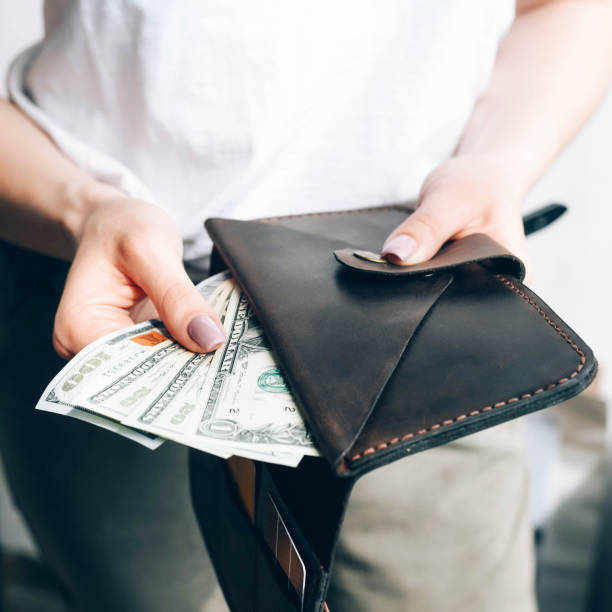 istock Wallet with dollar bills in female hands. 1243638934