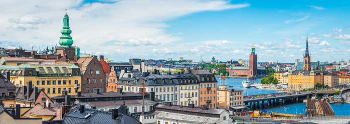 Panoramic view across Sodermalm to the landmarks and rooftops of central Stockholm, from the iconic tower of Stadshuset to the spires of Gamla Stan.